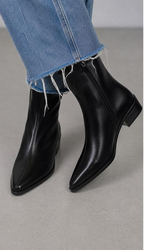 Botines de punta afilada en negro, llevados con vaquero recto