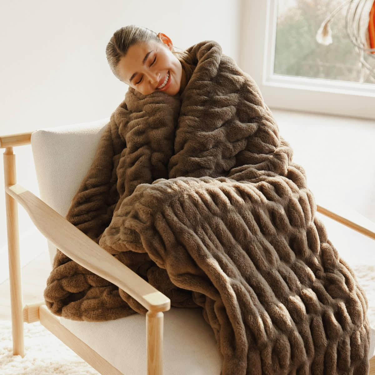 Manta Nube XXL en color Chocolate, mujer en un sillón